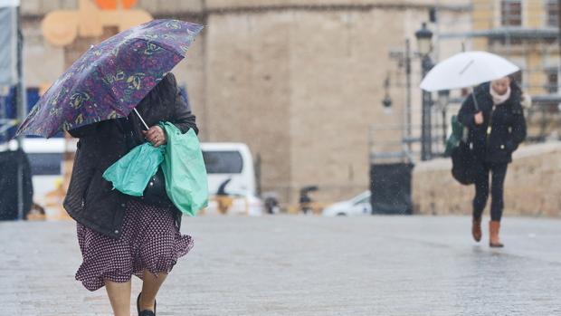 Unas mujeres se protegen de la lluvia en el centro de Valencia