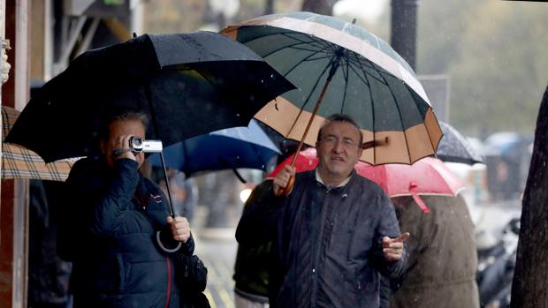 Unas personas se protegen de la lluvia en Valencia