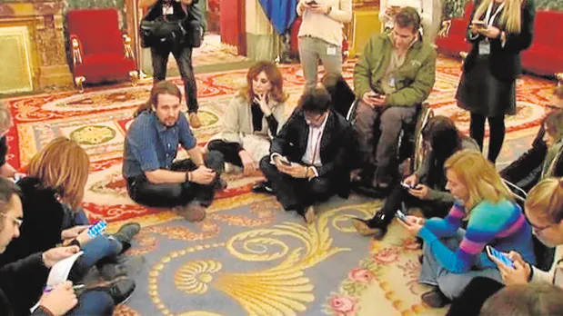 Pablo Iglesias rodeado de periodistas sentados en el suelo.