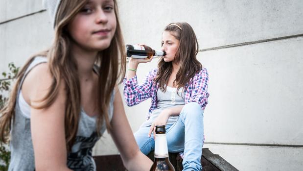 Dos jóvenes bebiendo cerveza en la calle