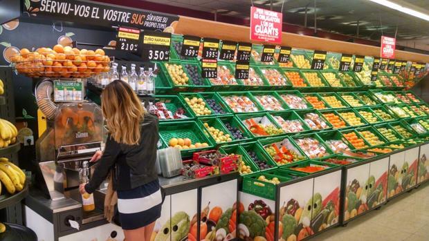 Imagen de una clienta dispensándose zumo de naranja en un supermercado de Mercadona