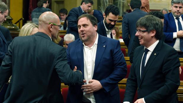 Romeva saluda a Oriol Junqueras en presencia de Carles Puigdemont, en el Parlamento de Cataluña
