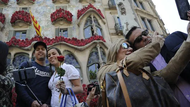 Dos parejas se fotgrafían ante la Casa Batlló durante el Sant Jordi de 2016