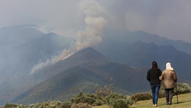 Dos personas contemplan el humo originado por el incendio en El Bierzo (León)