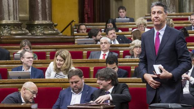Albiol pasa por la bancada en la que se sienta el gobierno autonómico, en el Parlamento de Cataluña
