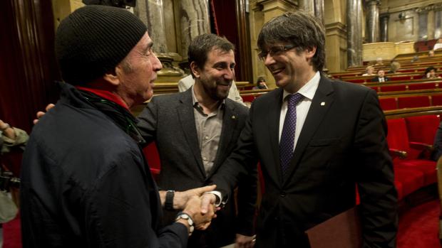 Lluís Llach saluda a Puigdemont en el Parlament