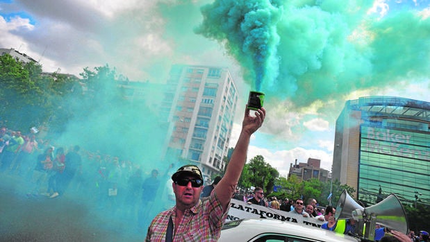 Un taxista levanta un tubo de humo durante la manifestación de este miércoles en Madrid