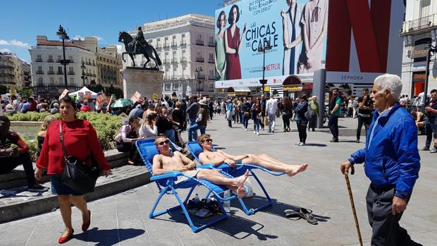 Los dos turistas tumbados en sus hamacas en medio de la Puerta del Sol