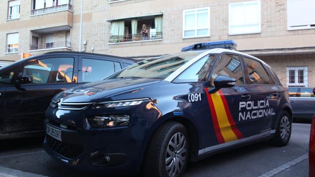 Un coche de la Policía Nacional, frente al edificio en el que vivía la víctima