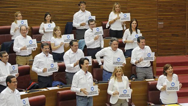 La bancada del PPCV, con camisas blancas y carteles en defensa de la libertad educativa