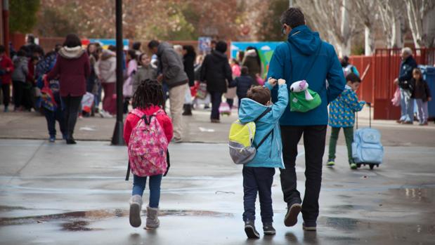 Un padre acompaña a sus hijos a la entrada al colegio