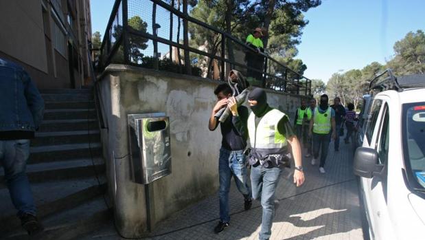 Miembros de los Mossos, con uno de los detenidos esta mañana en Tarragona