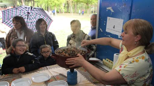 Una mujer cocina caracoles en la romería de San Marcos, en Palencia