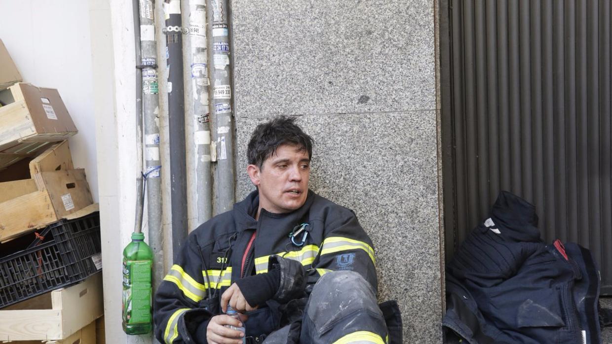 Un bombero, exhausto, durante las labores de extinción