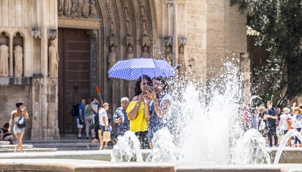 Unos turistas se protegen del calor en el centro de Valencia
