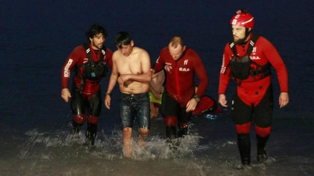 Personal de Emergencias saca del agua a un varón en la playa de Riazor