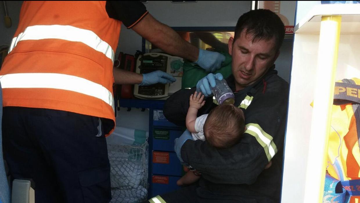 El bebé, entre los brazos de José Luis, un bombero del parque de Caspe (Zaragoza)