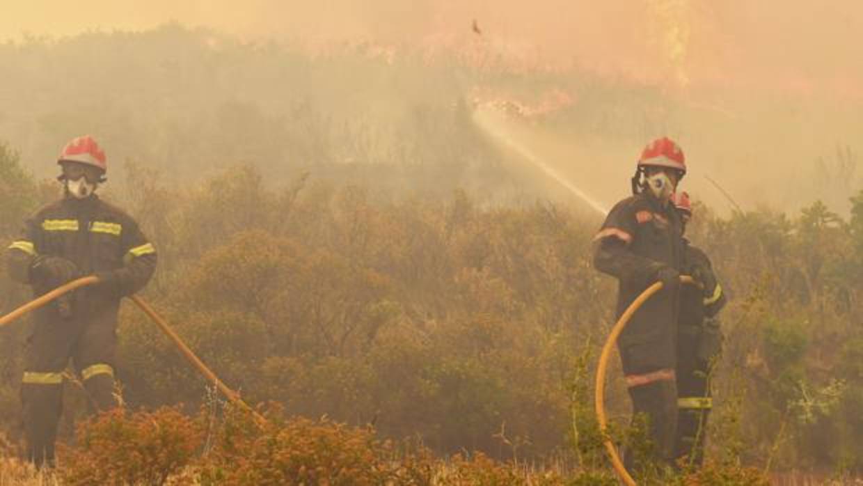 Dos bomberos trabajan en la extinción del incendio de la Calderona