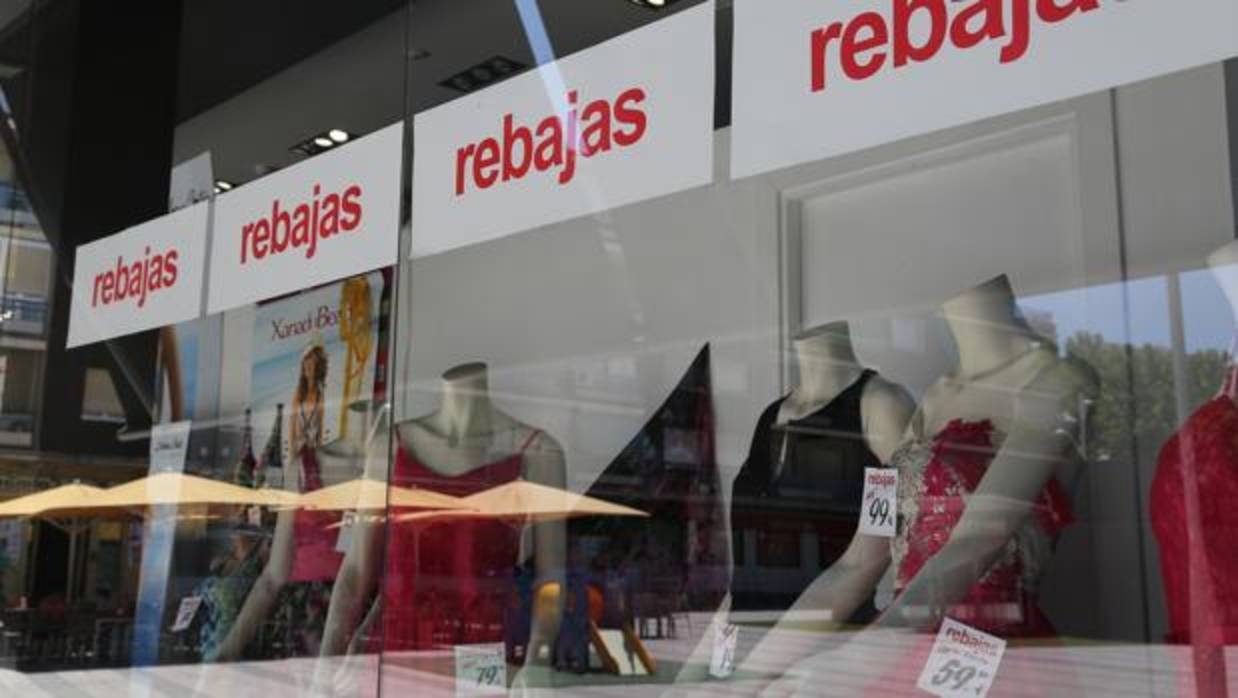 Un escaparate de una tienda de ropa con los carteles de rabajas