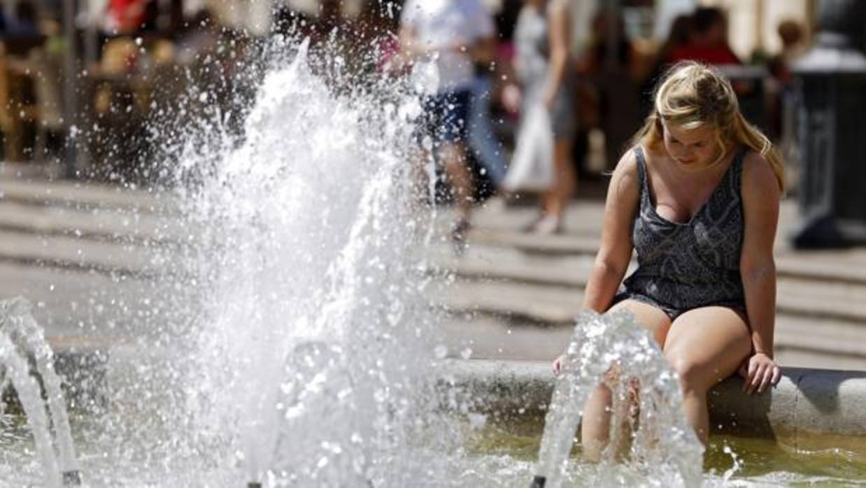 Una mujer se refresca en Valencia debido a la ola de calor de este mes de julio
