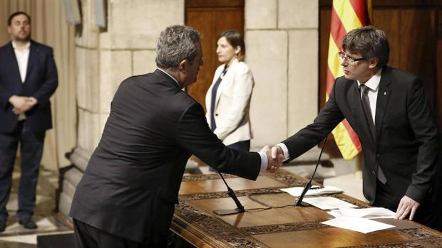 El nuevo conseller de Interior, Joaquim Forn, saluda a Puigdemont en la toma de posesión