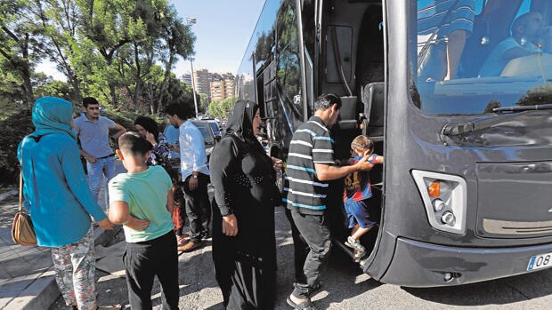 Varios refugiados esuben ayer por la tarde a un autobús para su traslado