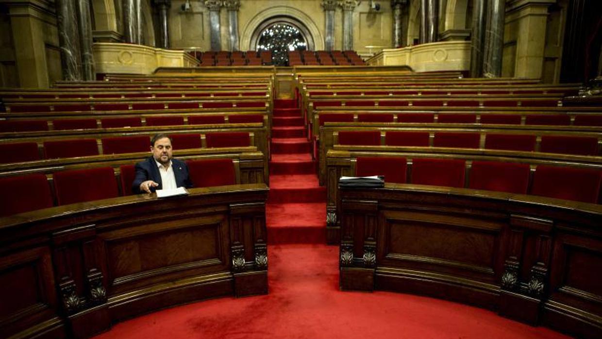 El vicepresidente catalán Junqueras ocupa su escaño minutos antes del comienzo de la sesión plenaria