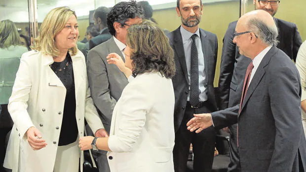 Pilar Del Olmo saluda a Soraya Sáenz de Santamaría en presencia de Cristóbal Montoro