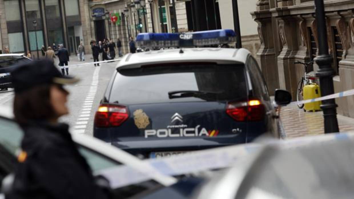 Imagen de archivo de un coche y un agente de la Policía Nacional de Valencia