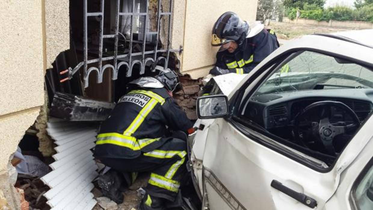 Los bomberos intervienen para sacar el coche y establizar la casa contra la que se ha emptrado en Matilla de la Vega (León)