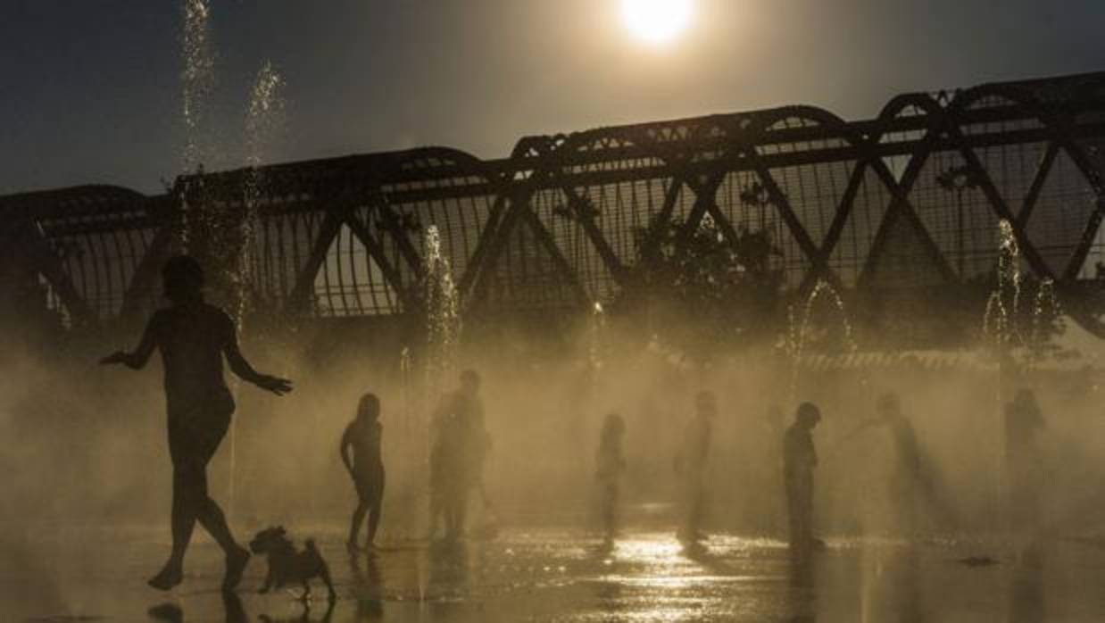Varias personas se refrescan en las fuentes de Madrid Río de la capital