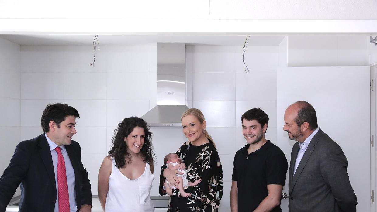 Cifuentes, junto a una pareja y su bebé, que acaban de recibir las llaves de su vivienda. Izq., el alcalde de Alcorcón, David Pérez; dcha., el consejero Pedro Rollán