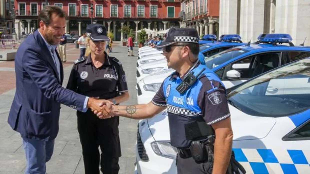 El alcalde Óscar Puente saluda a un agente local en la presentación de los nuevos automóviles de la Policía Municipal