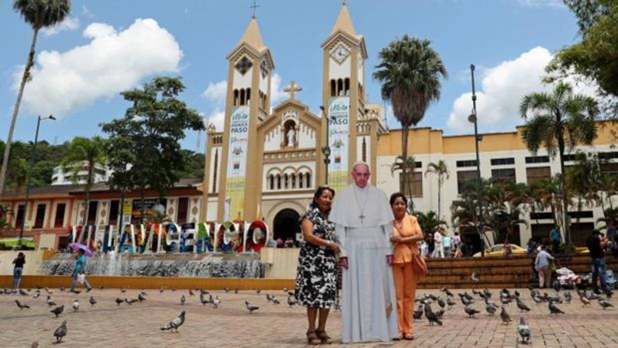 Dos mujeres se hacen una fotografía junto a una imagen del Papa Francisco en una de las ciudades colombianas de su periplo