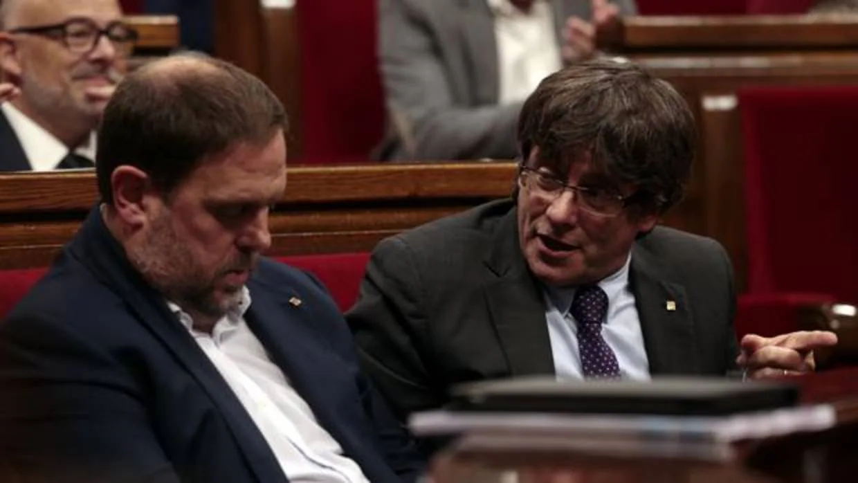Carles Puidemont, y Oriol Junqueras durante el pleno en el Parlament de Cataluña