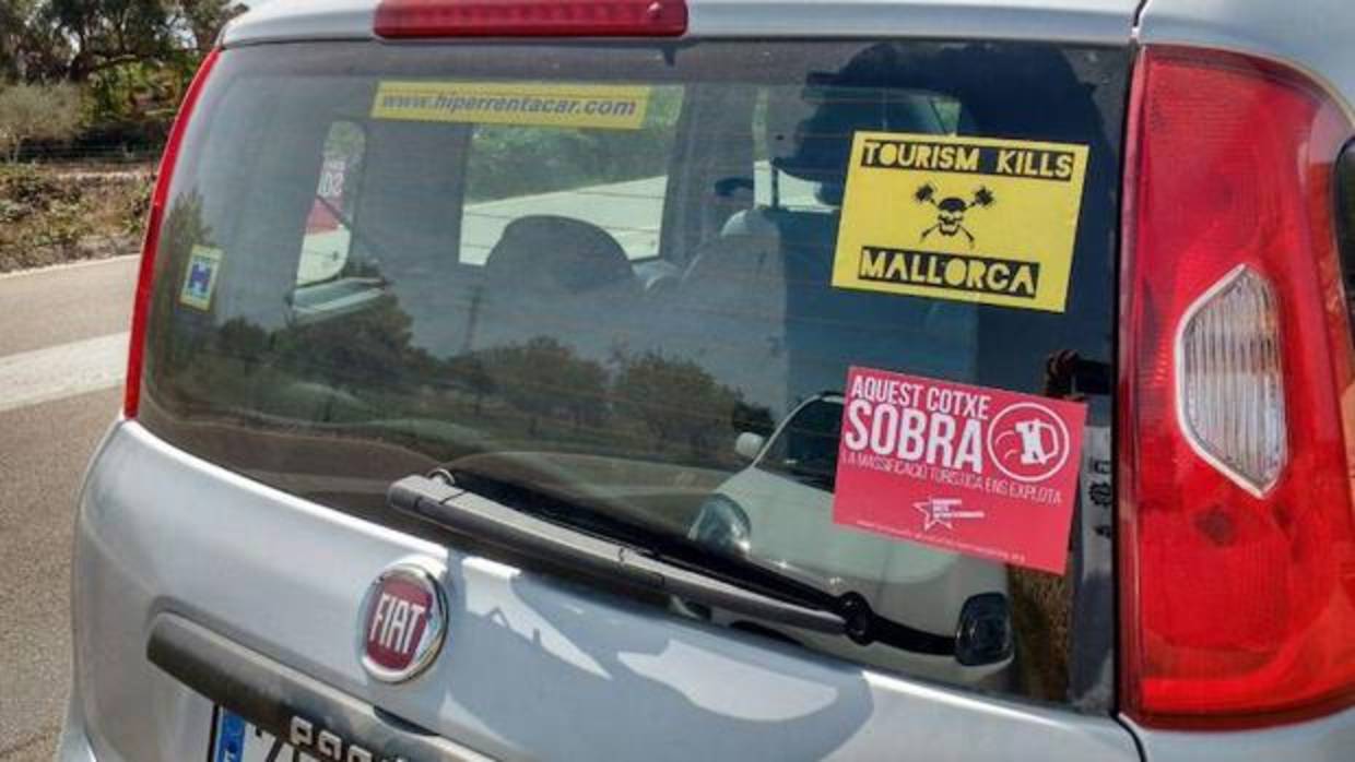 Un coche con pegatinas en contra del turismo en Palma de Mallorca