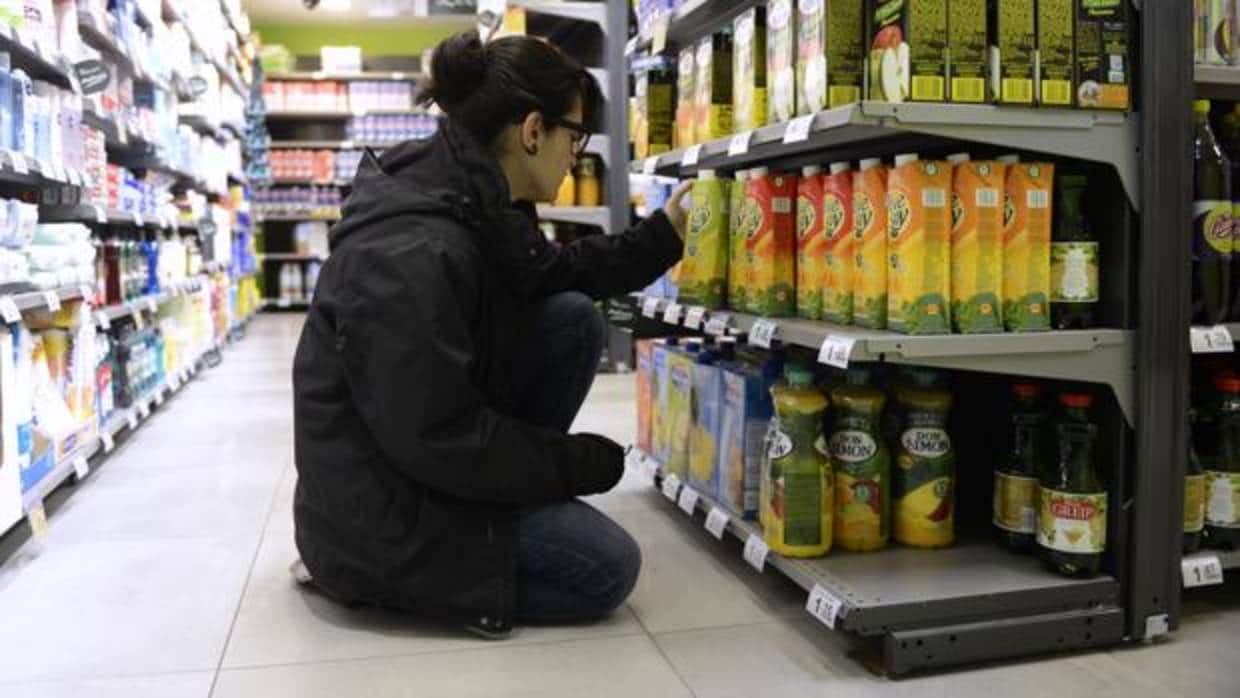 Una mujer compara precios en un supermercado