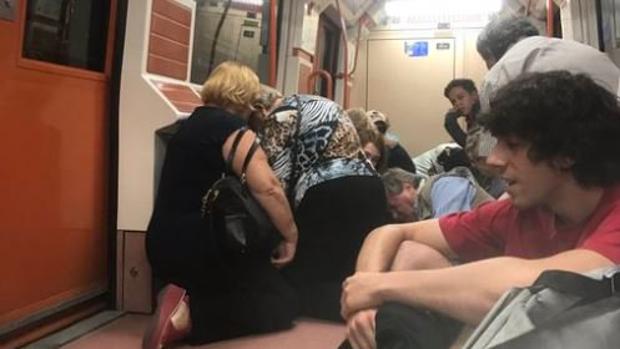 Varios viajeros se protegen agachados en el Metro de Madrid