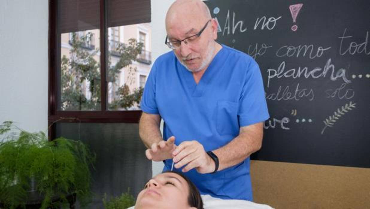 El doctor Argüello, especialista en medicina tradicional china, coloca una aguja en una paciente