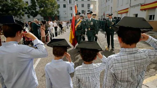 Cuatro niños saludan el paso de los guadias civiles hoy en Comandancia de València durante los actos de la Virgen del Pilar, patrona del cuerpo