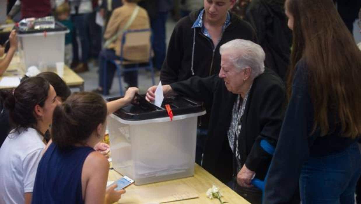 Una señora mete su voto en una urna durante el referéndum ilegal del 1-O