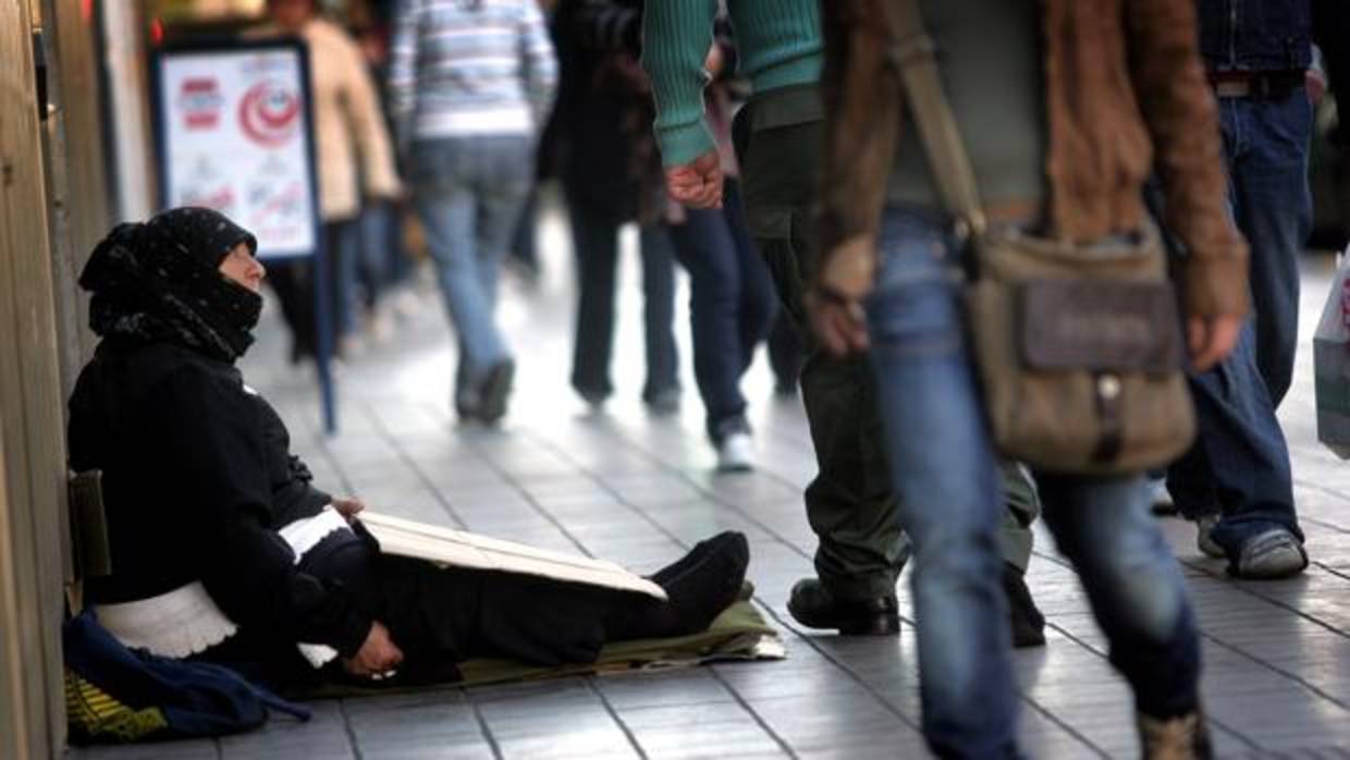 Una mujer pide limosna en las calles de Valencia