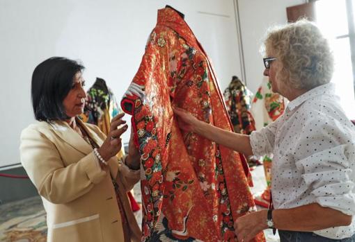 Dos conservadoras de la muestra dan retoques a una de las piezas