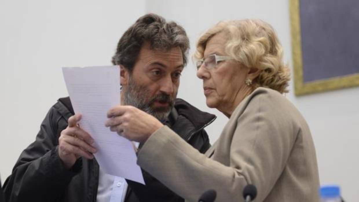 El concejal Mauricio Valiente comprueba unos documentos del pleno con la alcaldesa de Madrid, Manuela Carmena