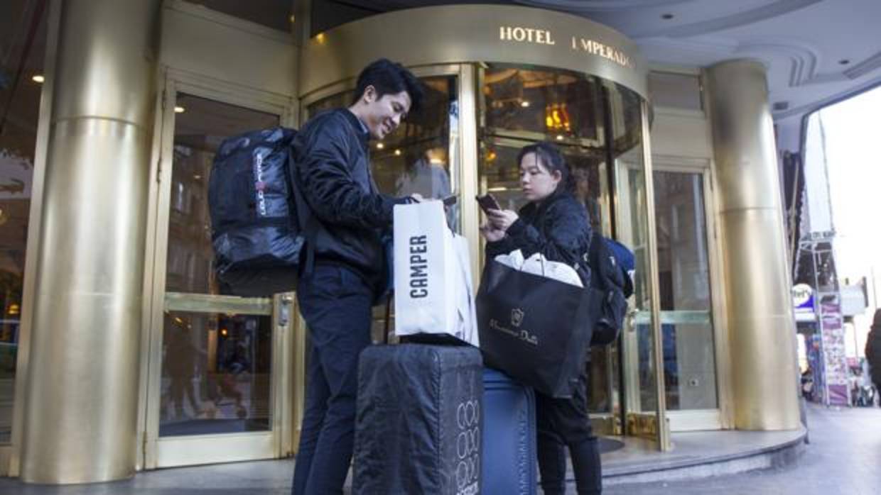 Una pareja de turistas asiáticos en la puerta del hotel Emperador