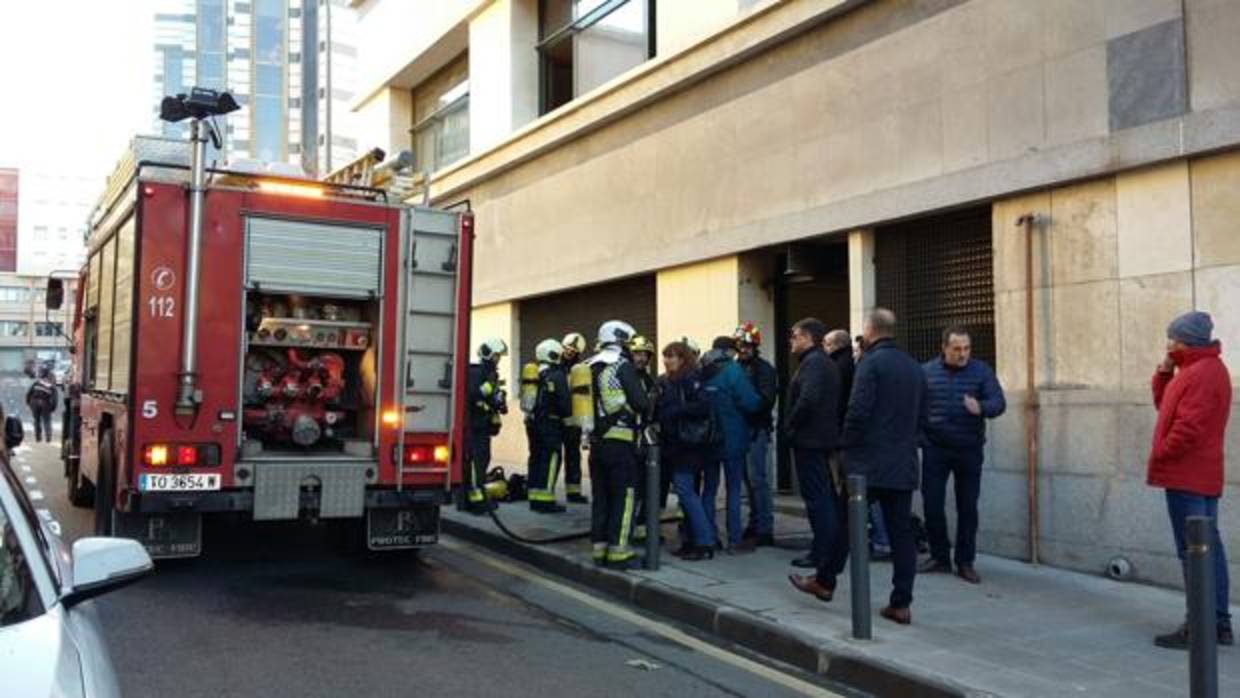 Bomberos y trabajadores de Telefónica junto al edificio desalojado