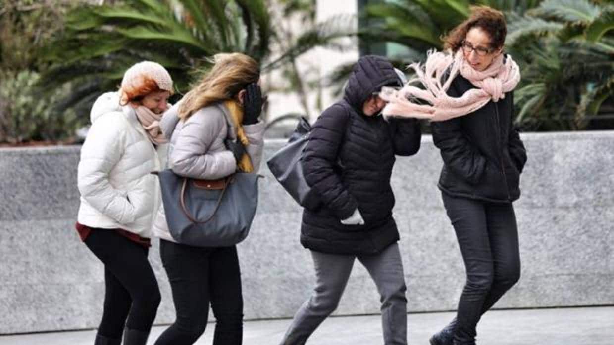 Varias transeúntes se protegen del frío y el viento en Valencia