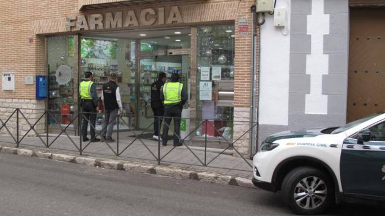 Cuatro investigadores, delante de una farmacia donde los detenidos compraron medicamentos con recetas falsas