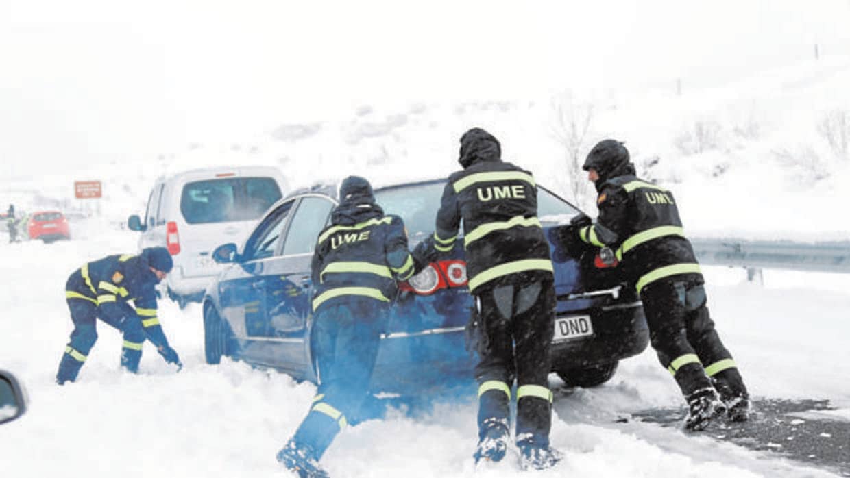 Efectivos de la UME ayudan a un vehículo a salir tras verse atrapado por la nevada en la AP-6