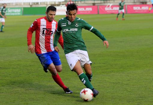 Charly Rodríguez intenta controlar un balón ante la presión de un adversario